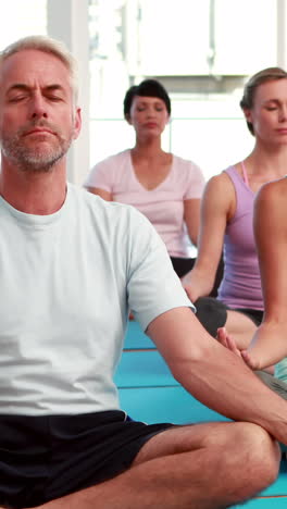 Yoga-class-sitting-in-lotus-position-together