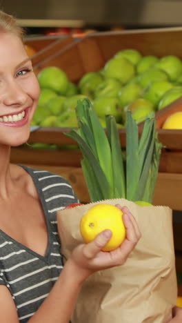 Smiling-blonde-with-paper-bag-picking-lemon