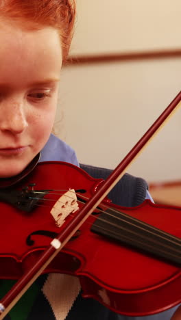 Cute-pupil-playing-violin-in-classroom