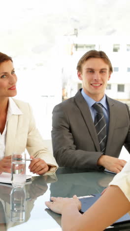 Businesswoman-being-interviewed-by-panel-and-being-offered-the-job