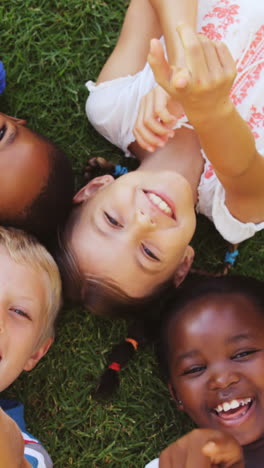 Group-of-kids-lying-on-grass-and-having-fun