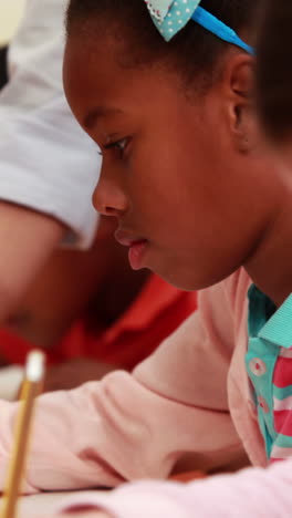 Teacher-helping-her-pupils-during-class