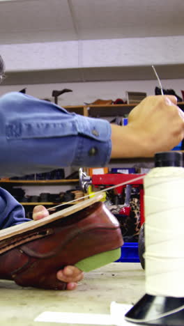 Cobbler-stitching-a-shoe-sole-with-needle