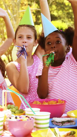 Grupo-De-Niños-Tocando-La-Bocina-De-Fiesta-Mientras-Celebran-Un-Cumpleaños