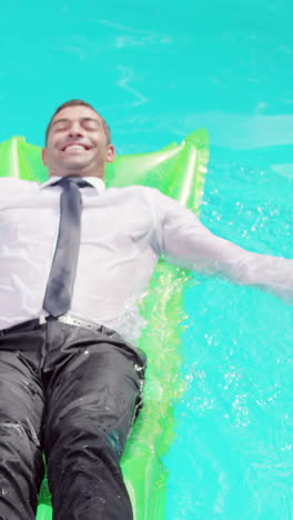 Businessman-lying-on-lilo-