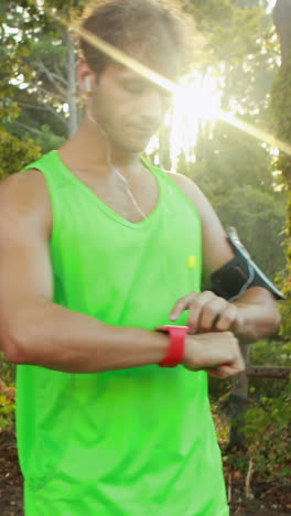 Man-checking-his-smartwatch-while-jogging-in-park