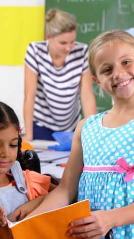 School-kids-reading-book-in-classroom