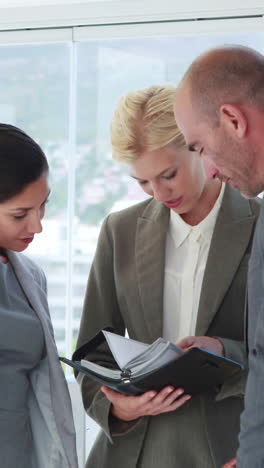 Business-people-looking-at-notebook-