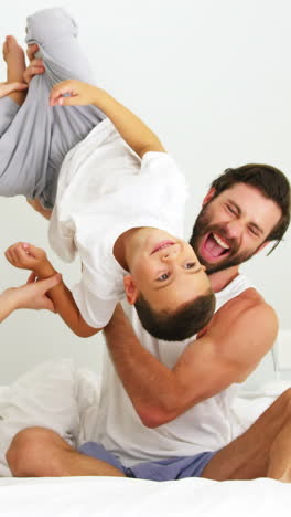 Happy-family-playing-together-on-a-bed