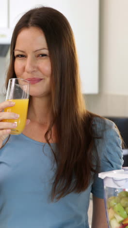 Mujer-Sonriente-Bebiendo-Un-Vaso-De-Jugo-De-Naranja