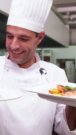 Smiling-handsome-chef-showing-two-dishes-to-camera