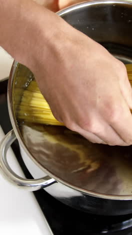 Man-cooking-pasta-in-saucepan