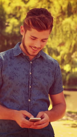 Handsome-man-texting-in-the-park