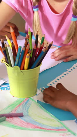 Preschool-class-drawing-at-table-in-classroom