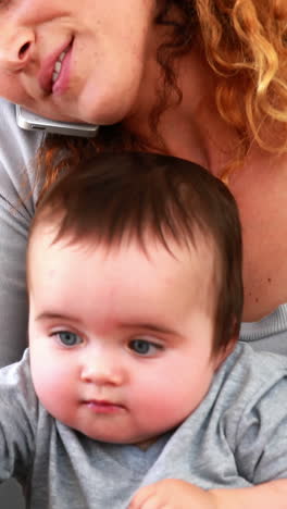 Mother-sitting-with-baby-son-on-lap-using-laptop