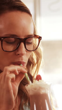 Smiling-woman-drinking-milkshake