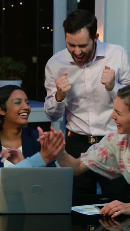 Business-executives-discussing-over-laptop