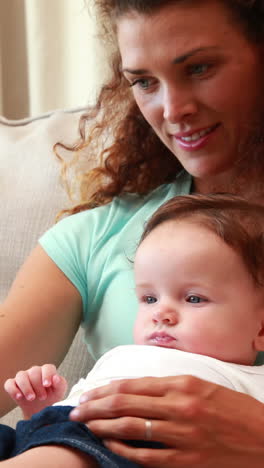 Mother-using-tablet-pc-with-baby-son-on-her-lap