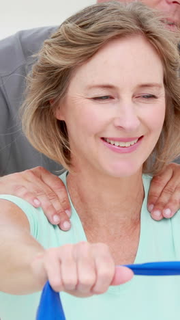 Physiotherapist-checking-patient-stretching-resistance-band