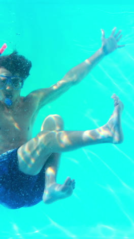 Man-in-snorkel-jumping-in-swimming-pool-waving-at-camera