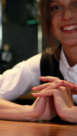 Smiling-bartender-in-uniform-cleaning-