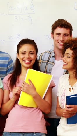 Estudiantes-De-Pie-En-El-Aula-Dando-Pulgares-A-La-Cámara