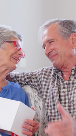 Cute-elderly-woman-receiving-present-from-husband