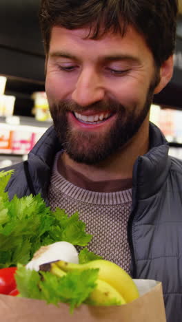 Man-holding-fruits-and-vegetables-in-paper-bag