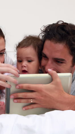 Loving-parents-with-baby-daughter-using-tablet