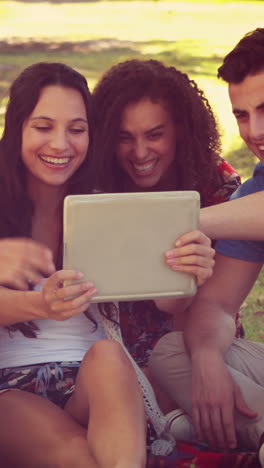 Amigos-Felices-Usando-Tableta-En-El-Parque