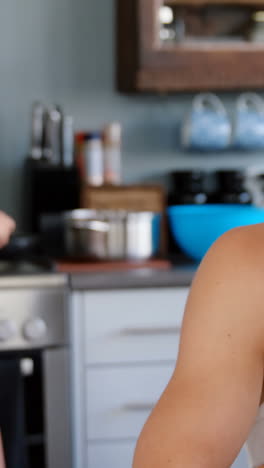 Attractive-woman-cooking-while-man-using-smartphone