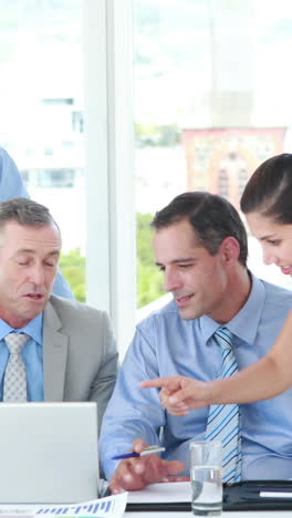 Business-people-looking-at-laptop-computer-during-meeting