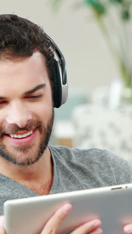 Happy-young-man-using-his-tablet