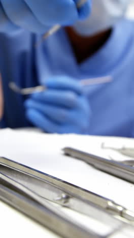 Dentist-examining-a-young-patient-with-tools