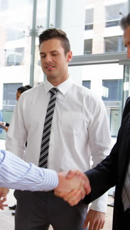 Businessmen-shaking-hands-in-office