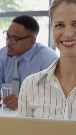 Close-up-on-a-businesswoman-smiling-and-using-a-laptop