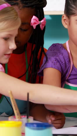 Preschool-class-painting-at-table-in-classroom