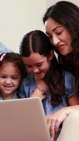 Familia-Feliz-Usando-Una-Computadora-Portátil-En-El-Sofá