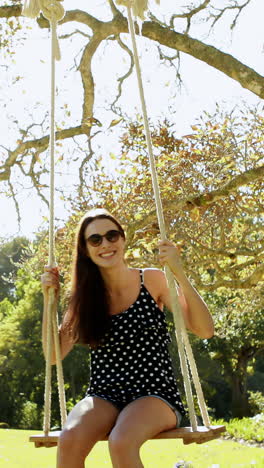 Young-woman-swinging-on-swing-in-park