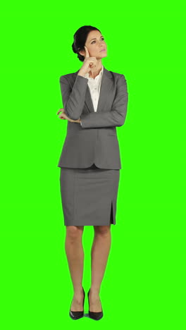 Thoughtful-business-woman-standing-and-smiling-at-the-camera