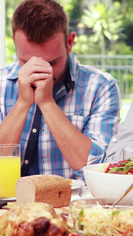 Family-praying-before-eating-lunch-