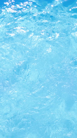 Overhead-of-brunette-swimming-in-pool-on-sunny-day