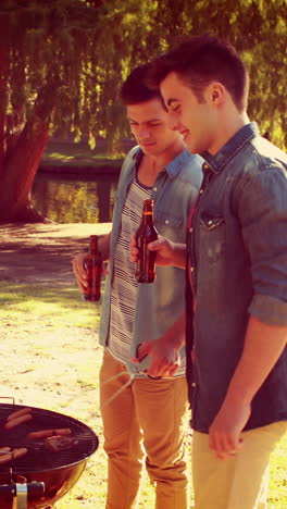 Three-friends-in-the-park-having-barbecue-and-drinking-beer