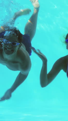 Three-friends-diving-into-swimming-pool-and-waving