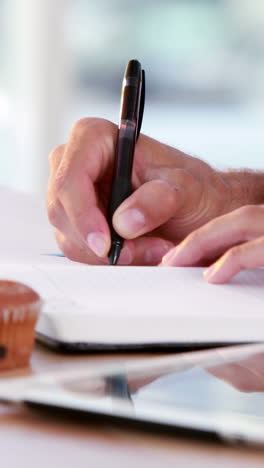 Hands-of-casual-business-man-writing-on-paper-