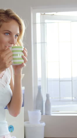 Cute-blonde-having-coffee-in-kitchen