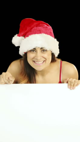 Beauty-brunette-in-santa-hat-showing-white-poster