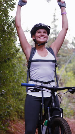 Female-cyclist-standing-with-mountain-bike