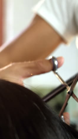 Woman-getting-his-hair-trimmed-with-scissor