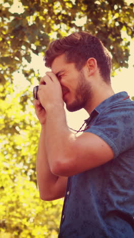 Gutaussehender-Mann-Mit-Retro-Fotokamera-Im-Park